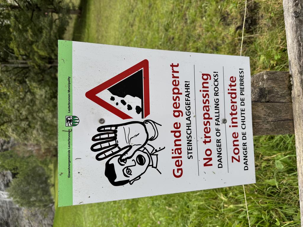 A sign warning me not to cross the barrier, as rocks can fall from the nearby cliff face